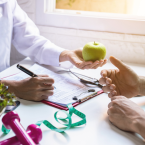 Nutritionist giving consultation to patient with healthy fruit and vegetable